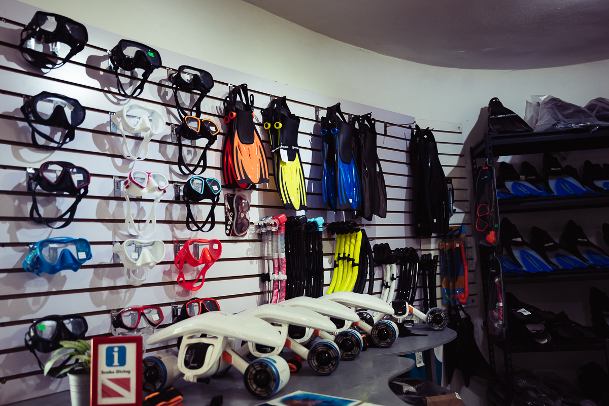 Scuba masks, fins and diving equipment displayed inside The Dive Academy office