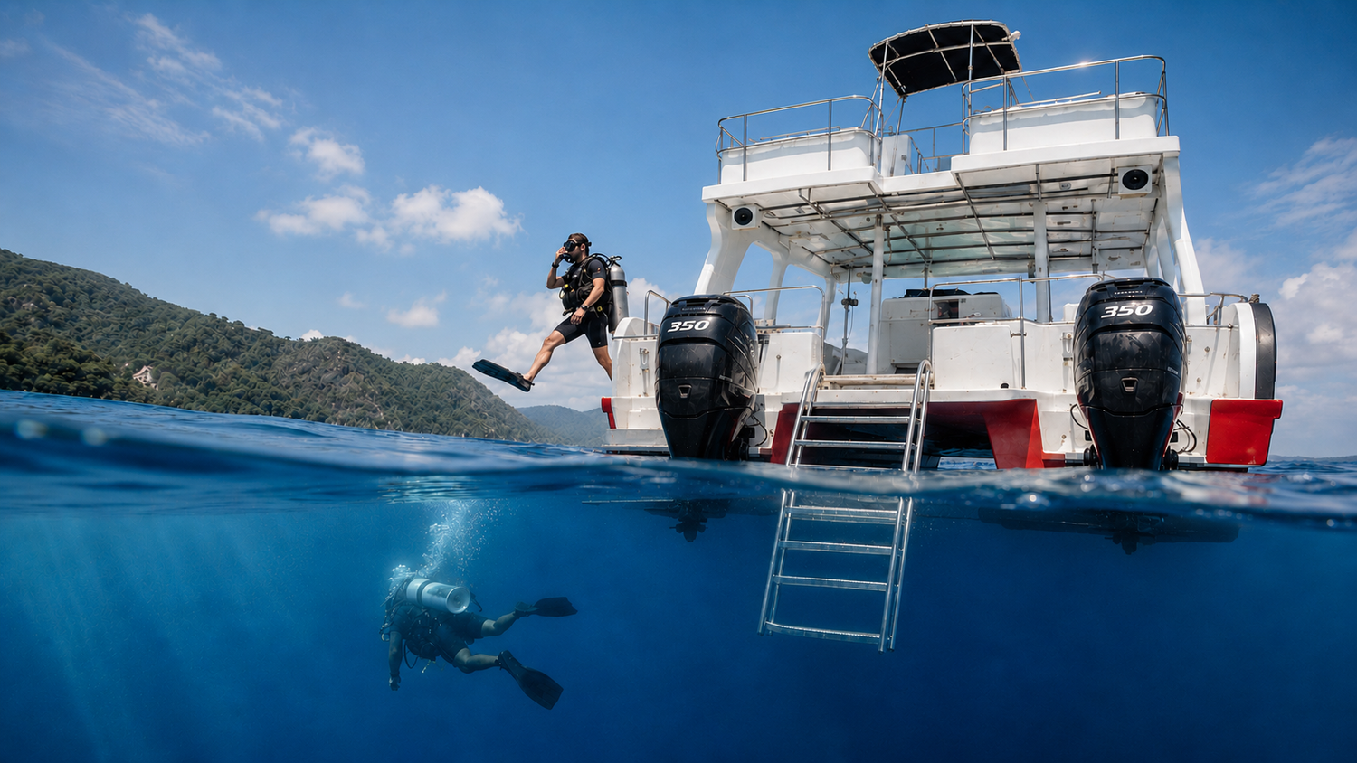 Scuba divers entering the water from the Antares dive boat near Las Terrenas